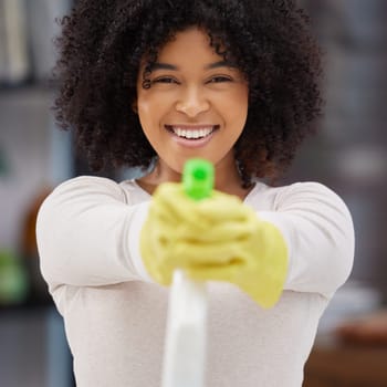 Portrait, home and woman with spray bottle, spring cleaning and housekeeping with smile, container and remove bacteria. Face, happy person and girl with liquid product, hygiene and gloves for safety.