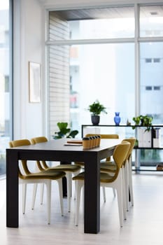 Empty office, meeting room and coffee cup on table with paperwork, seminar setup or advisory business workshop. Notebook, workspace and furniture in boardroom at consulting agency for conference.