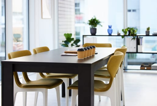 Empty office, conference room and coffee on table with paperwork, seminar setup or advisory business workshop. Notebook, paper cup and furniture in boardroom at consulting agency for training meeting.