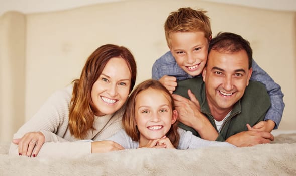 Happy family, parents and children with face on bed for bonding, peace or love at home in bedroom. Connection, smile and people in house and apartment for holiday, vacation or relax together with hug.