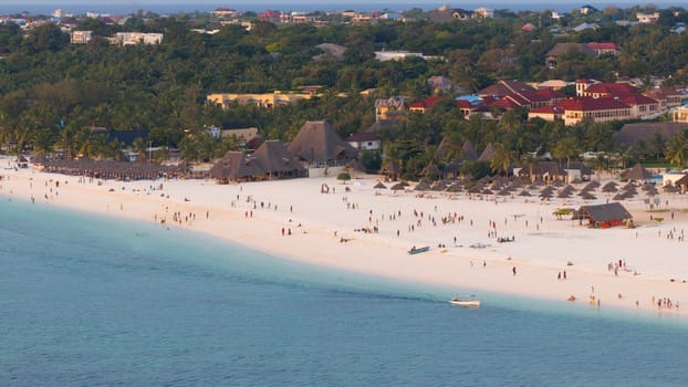 Kendwa beach with a lot of people and a boat in the water. Scene is relaxed and fun, summer concept, Tanzania, Zanzibar