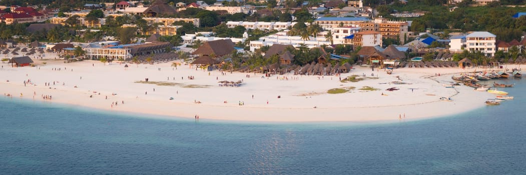 Kendwa beach with a lot of people and a boat in the water. Scene is relaxed and fun, summer concept, Tanzania, Zanzibar