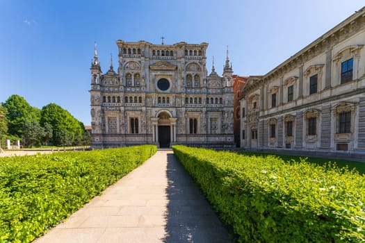 Certosa di Pavia monastery, historical monumental complex that includes a monastery and a sanctuary. green court and a church.The Ducale Palace on the right,Pavia,Italy.