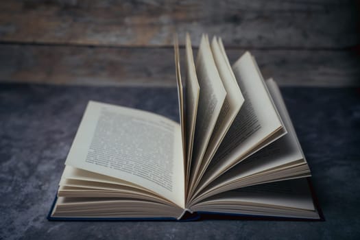 Open book on a gray wood background. High quality photo