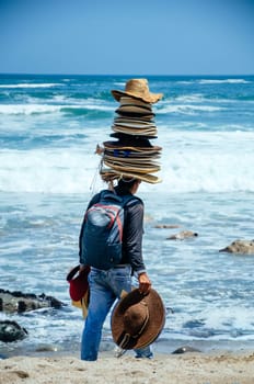 Seller of hats with many hats on his head, on a beach in Lima - Peru
