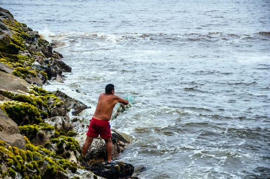 Fisherman pulling fishing net on the beaches of Lima, Peru