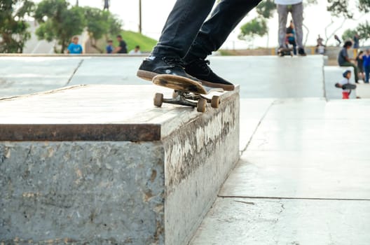 Skater doing a trick in the skatepark called grind o 50 - 50