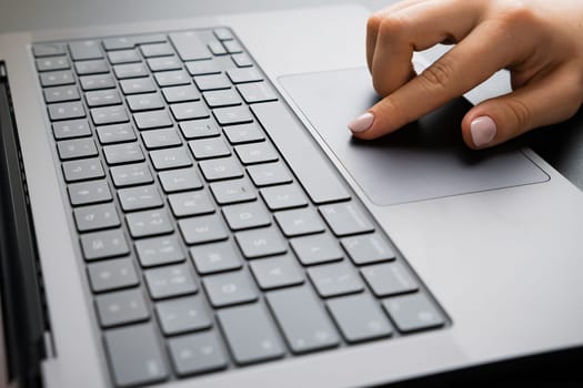 BERLIN, GERMANY - APRIL 14 2024: Female hand working on a computer touchpad. Business office workplace concept.