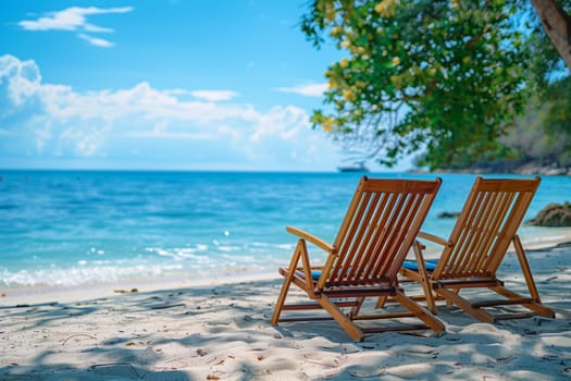 Two weathered wooden chairs placed on a sandy beach, overlooking the sea. The chairs stand empty in the warm sunlight.