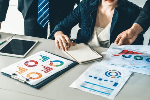 Businessman and businesswoman in meeting working with many financial statement document on desk. Concept of busy business profit analysis and brainstorm. Close up shot at people hands and papers. uds