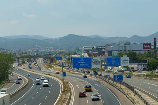 Bellaterra, Spain - May 24, 2023: A highway filled with multiple cars driving in separate lanes. The vehicles are moving at various speeds in a common direction, creating a busy and active scene.