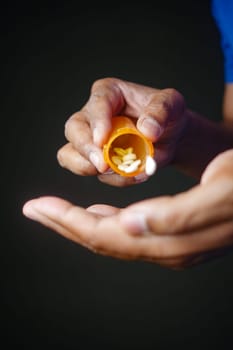 Close up of person hand holding pill container .