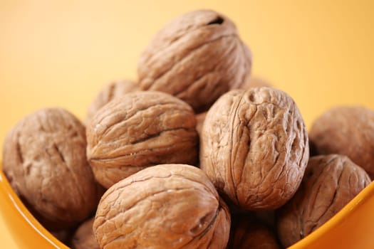 natural walnut in a bowl on yellow background ,