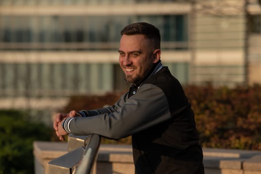 Portrait of a smiling bearded man outdoors at sunset