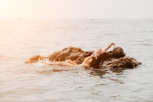 Woman travel sea. Young Happy woman in a long red dress posing on a beach near the sea on background of volcanic rocks, like in Iceland, sharing travel adventure journey