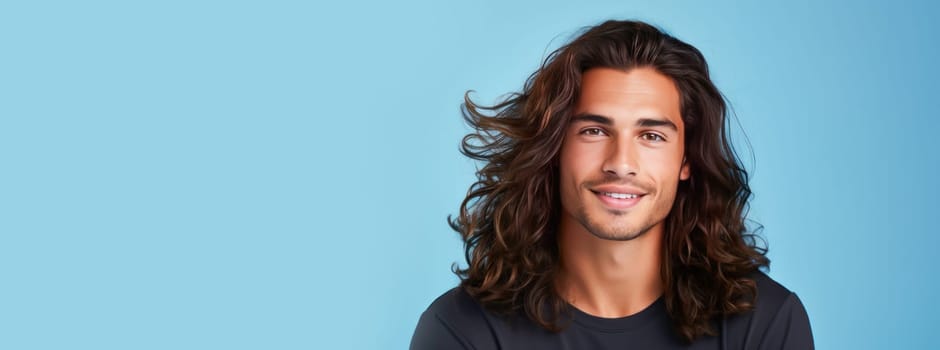 Portrait of an elegant sexy smiling Latino man with perfect skin and long hair, on a light blue background. Advertising of cosmetic products, spa treatments shampoos and hair care products, dentistry and medicine, perfumes and cosmetology for men