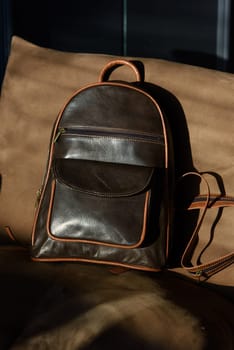 Brown leather backpack on chair, close up..