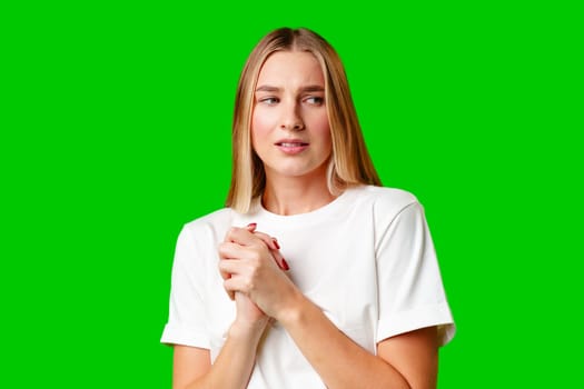 Young Woman With Pursed Lips Expressing Skepticism Against Green Screen Background in studio