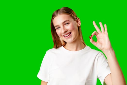 Young Woman Giving Thumbs Up Sign on Green Screen in studio