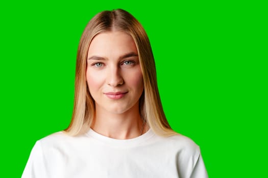 Young Woman in White Shirt Posing for Picture against green background in studio