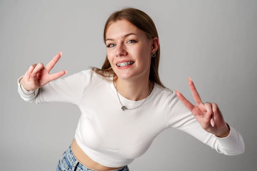 Young Woman Making Peace Sign With Hands in studio close up