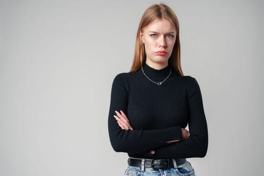 Young Woman Wearing Black Top and Jeans against gray background close up