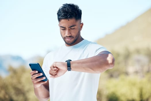 Man, fitness and checking time with watch in nature for tracking performance, steps or workout schedule. Male person, runner or athlete with wristwatch for monitoring heart rate in outdoor exercise.