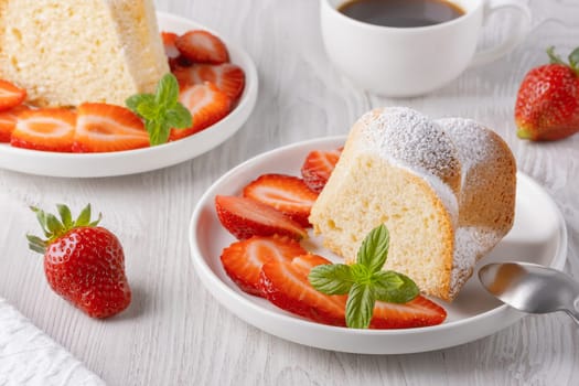 Piece of cupcake with strawberries on a plate.