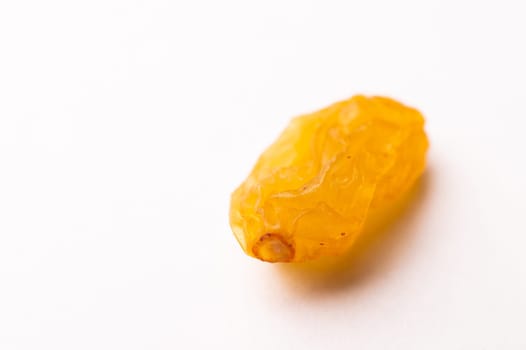 macro photograph of one raisin on a white background, side view.