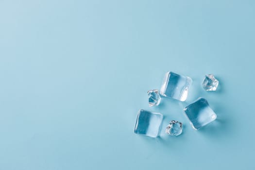 top view of ice cubes of different sizes on blue background