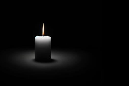 burning white candle on a black background, copy space.