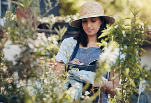 Notebook, gardening and woman checking flowers for botany, growth or development in nature. Botanist, sustainable and female florist with research for floral plants in eco friendly environment