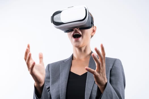 Business woman holding something while wearing VR goggle and standing at white background. Project manager with headset enter visual reality world program by using technology innovation. Contraption.