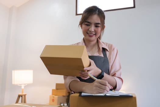 Startup small business entrepreneur SME, asian woman receive order on phone. Success young Asian small business owner home office, online sell marketing delivery.