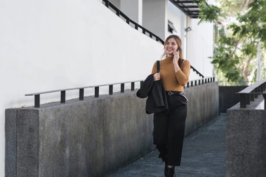 A woman is talking on her cell phone while walking down a stairway.