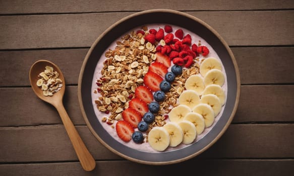 Colorful smoothie bowl in a coconut shell, topped with banana, goji berries, granola, and coconut flakes.