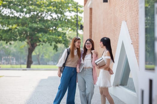 College friends walk to class together. University student in campus talk and have fun outdoors.