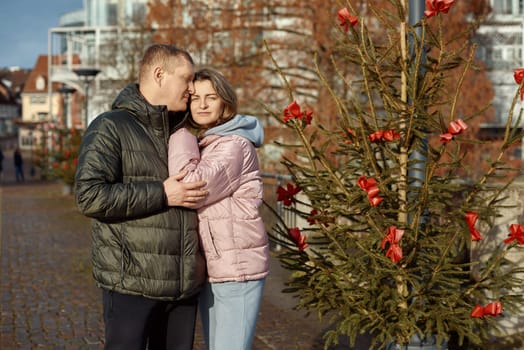 Portrait of young attractive people, lovely couple enjoying cozy atmosphere on fair in Christmas Eve. Spending time together. Concept of national traditions, winter holidays, fashion, festivities