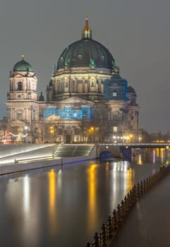 Berlin, Germany - Dec 19, 2023 - Picturesque view of The historic berlin cathedral building with a bridge over the river Spree at dusk. Berlin Cathedral Berliner Dom in Berlin, Space for text, Selective focus.