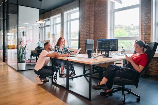 A diverse group of business professionals collaborates in a modern startup coworking center, utilizing a mix of paper-based and technological tools such as mobile phones and computers .