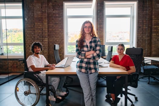 A diverse group of business professionals collaborates in a modern startup coworking center, utilizing a mix of paper-based and technological tools such as mobile phones and computers .