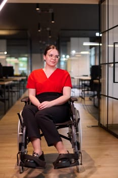 A modern young businesswoman in a wheelchair is surrounded by an inclusive workspace with glass-walled offices, embodying determination and innovation in the business world.