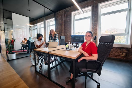 A diverse group of business professionals collaborates in a modern startup coworking center, utilizing a mix of paper-based and technological tools such as mobile phones and computers .