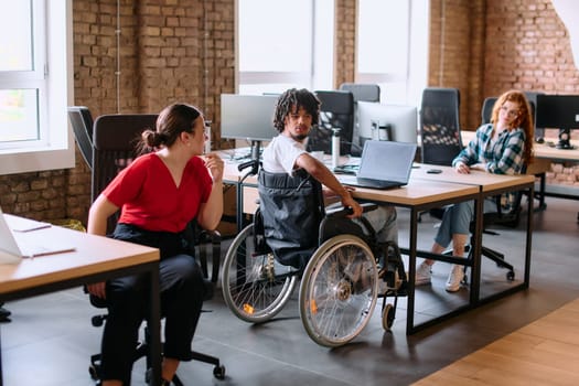 A diverse group of business professionals collaborates in a modern startup coworking center, utilizing a mix of paper-based and technological tools such as mobile phones and computers .