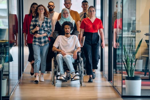 A diverse group of young business people congregates within a modern startup's glass-enclosed office, featuring inclusivity with a person in a wheelchair, an African American young man, and a hijab muslim woman