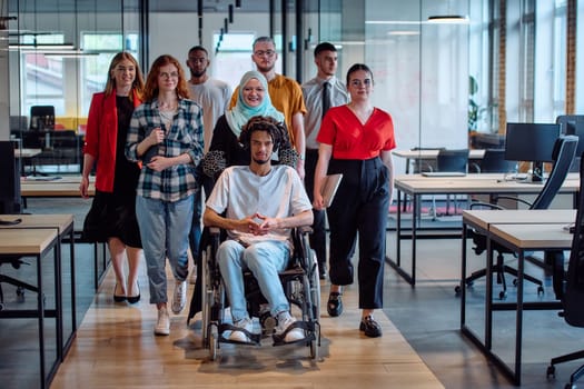 A diverse group of young business people congregates within a modern startup's glass-enclosed office, featuring inclusivity with a person in a wheelchair, an African American young man, and a hijab muslim woman