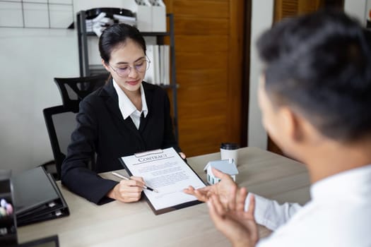 Real Estate Concept. real estate agent and client sign contract of property after discussing the details.