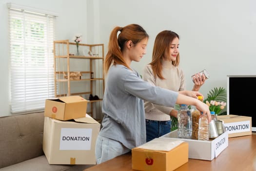 charity, donation and volunteering concept. Volunteer prepare foodstuff box containing food to donate to people poor, disaster victim at home.