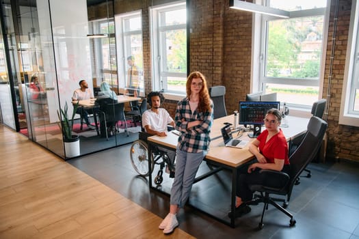 A diverse group of business professionals collaborates in a modern startup coworking center, utilizing a mix of paper-based and technological tools such as mobile phones and computers .