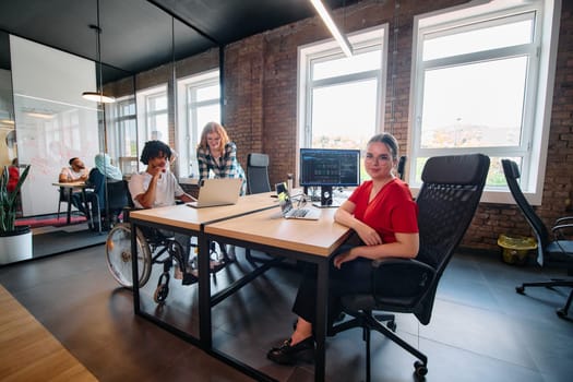 A diverse group of business professionals collaborates in a modern startup coworking center, utilizing a mix of paper-based and technological tools such as mobile phones and computers .
